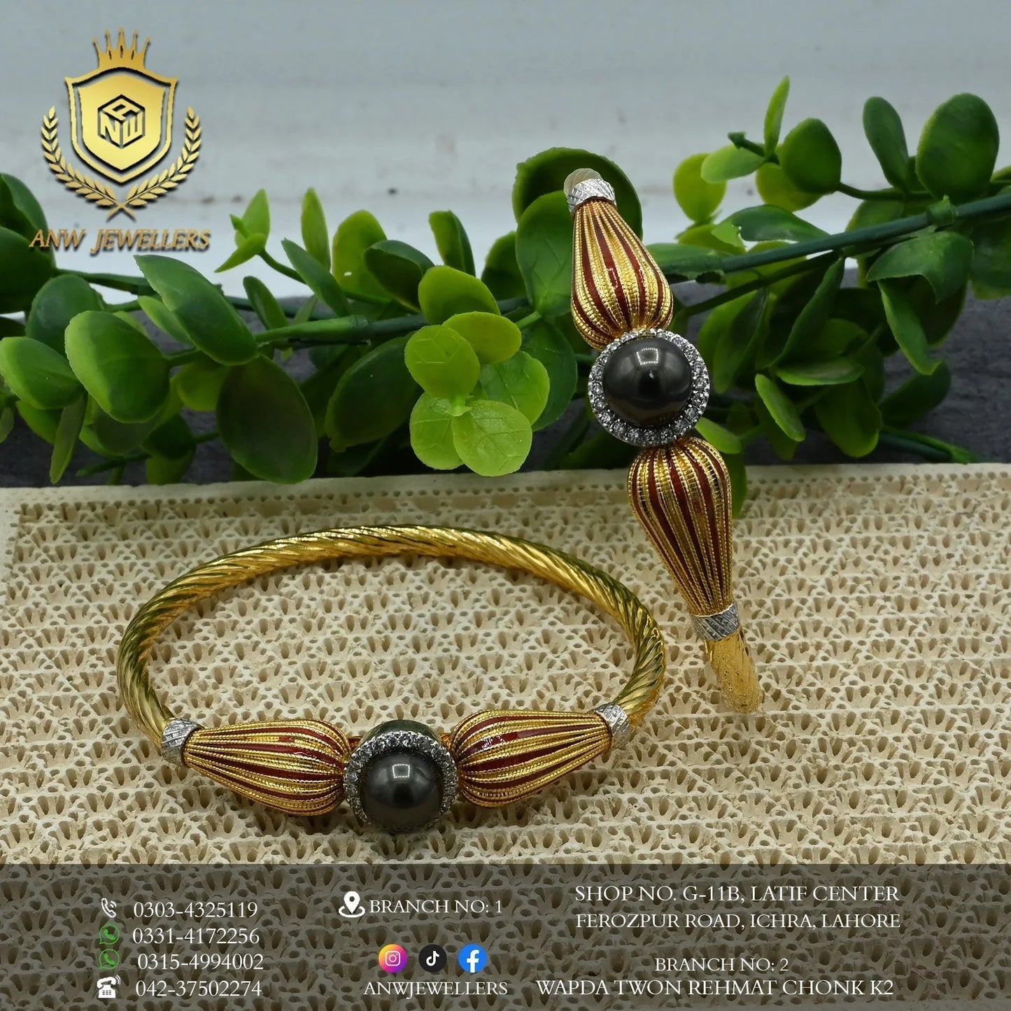 Gold bangles with black stone and red accents by ANW Jewellers on textured display