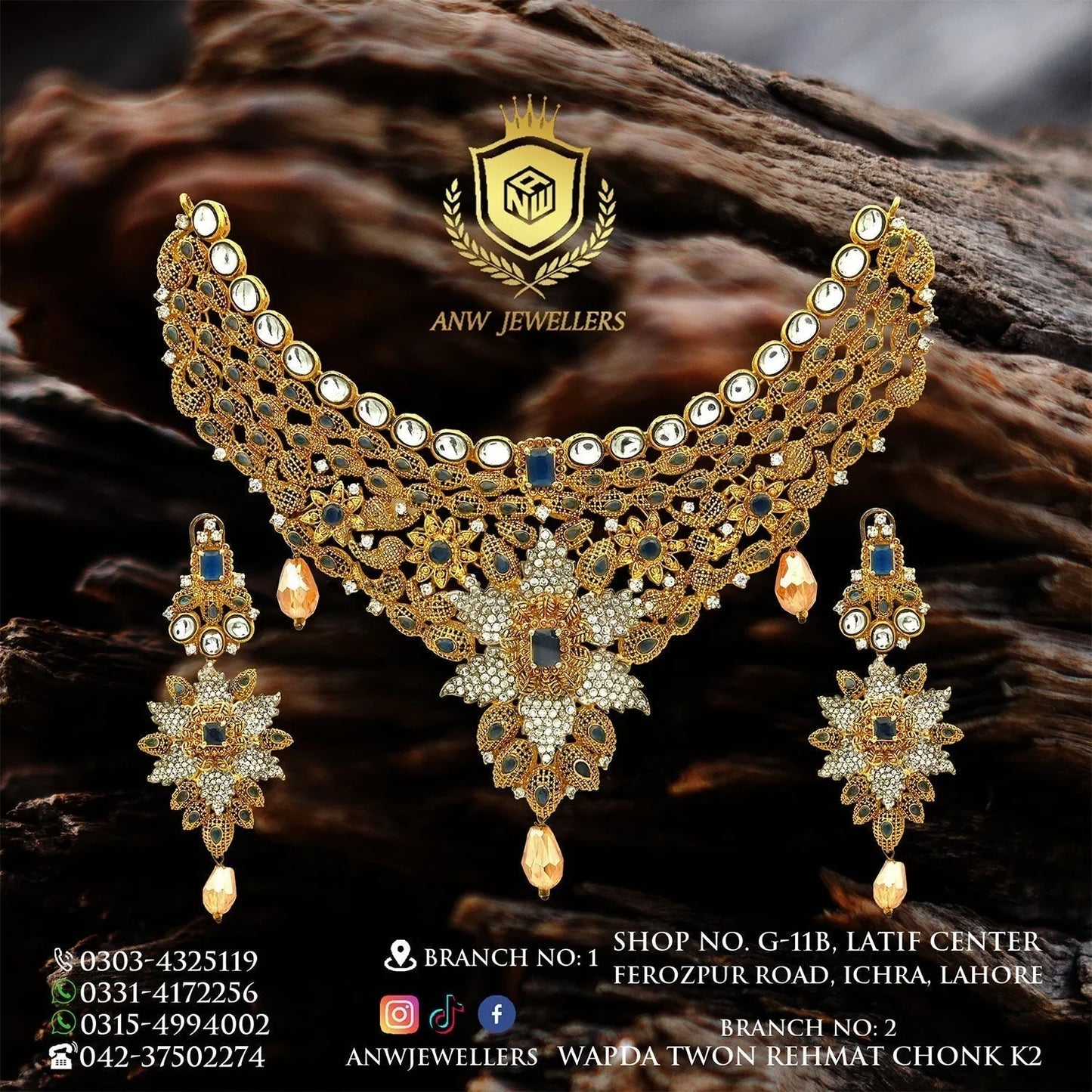 Gold bridal jewelry set with blue and white stones by ANW Jewellers, displayed on a dark background.