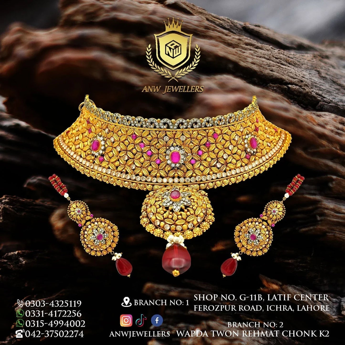 Gold bridal jewelry set with intricate floral designs, ruby accents, and dangling red gemstones.