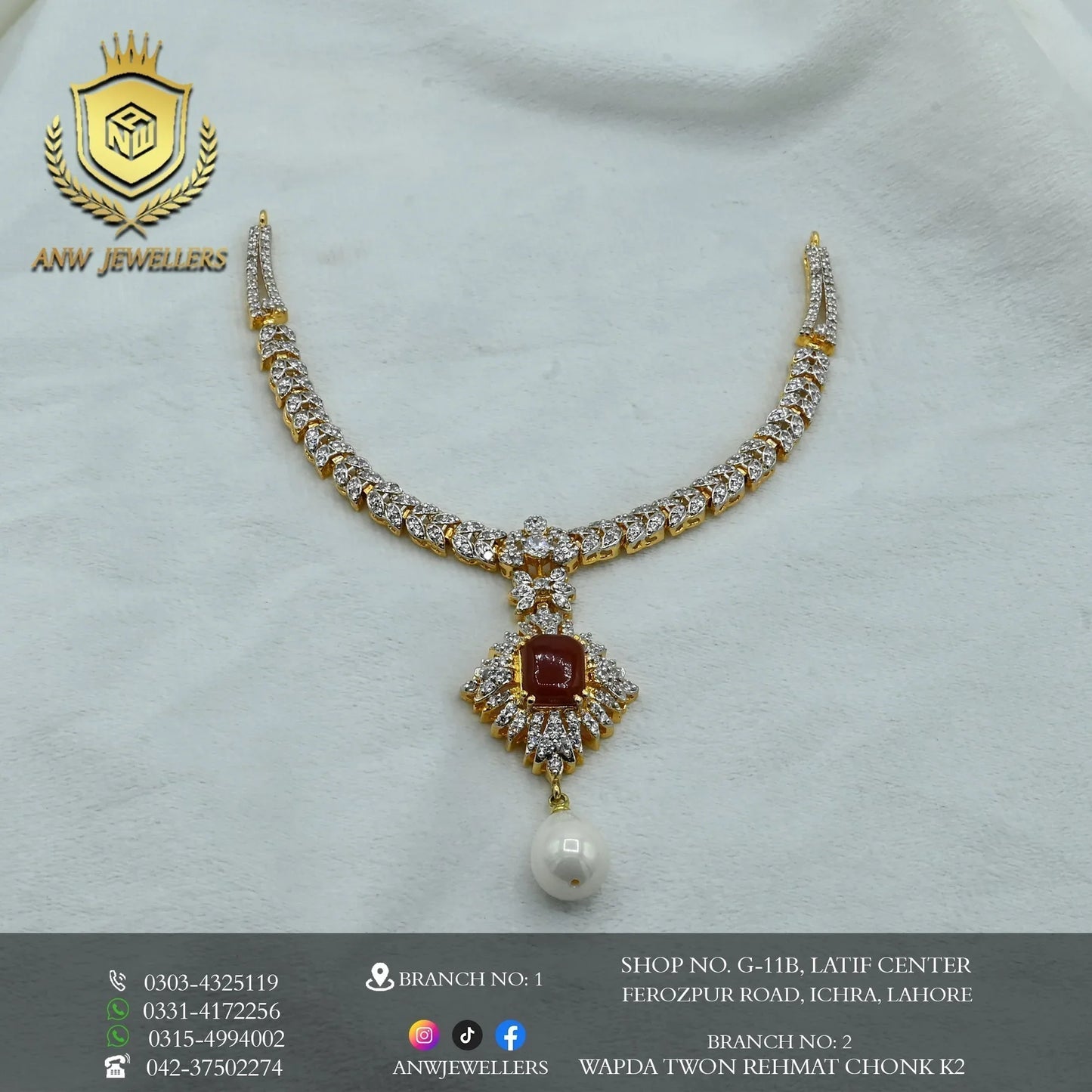 Gold diamond necklace with red gemstone and pearl pendant on white background, ANW Jewellers logo.
