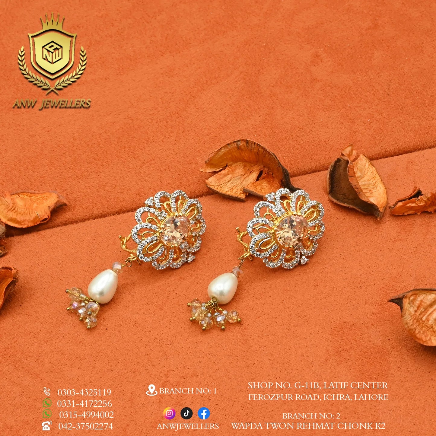 Gold and diamond studded earrings with pearl drops by ANW Jewellers on orange velvet.