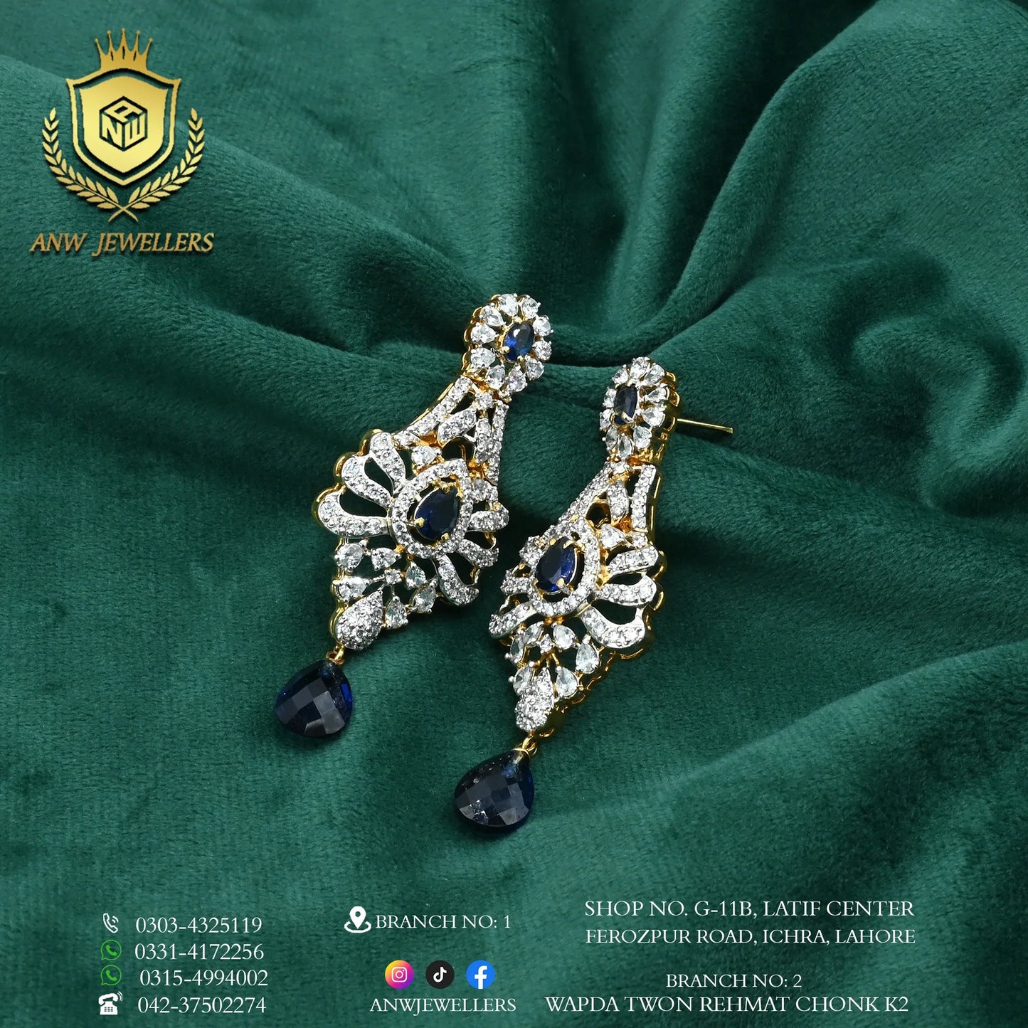 Gold earrings with blue and white stones on green velvet, ANW Jewellers branding