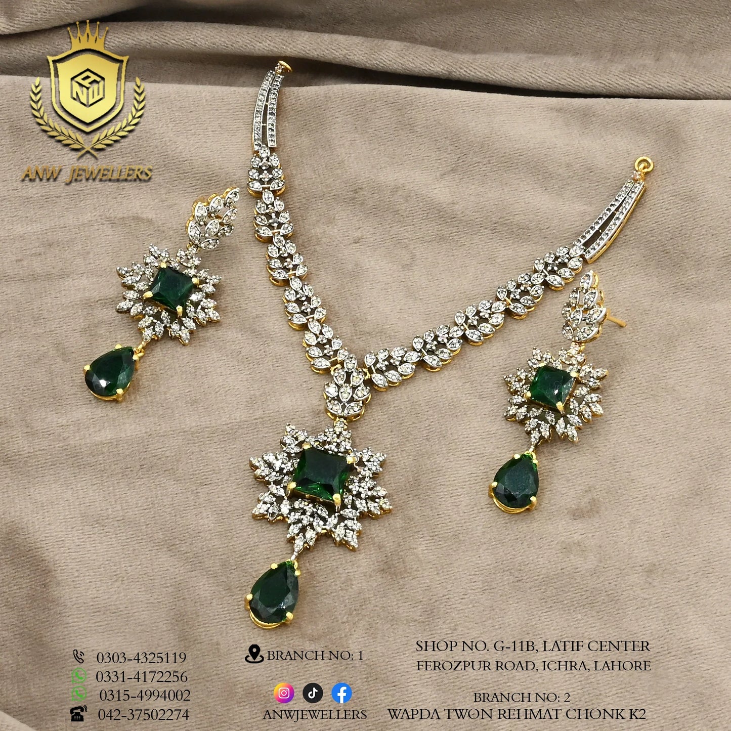 Gold jewelry set with green gemstones and diamonds by ANW Jewellers on beige fabric