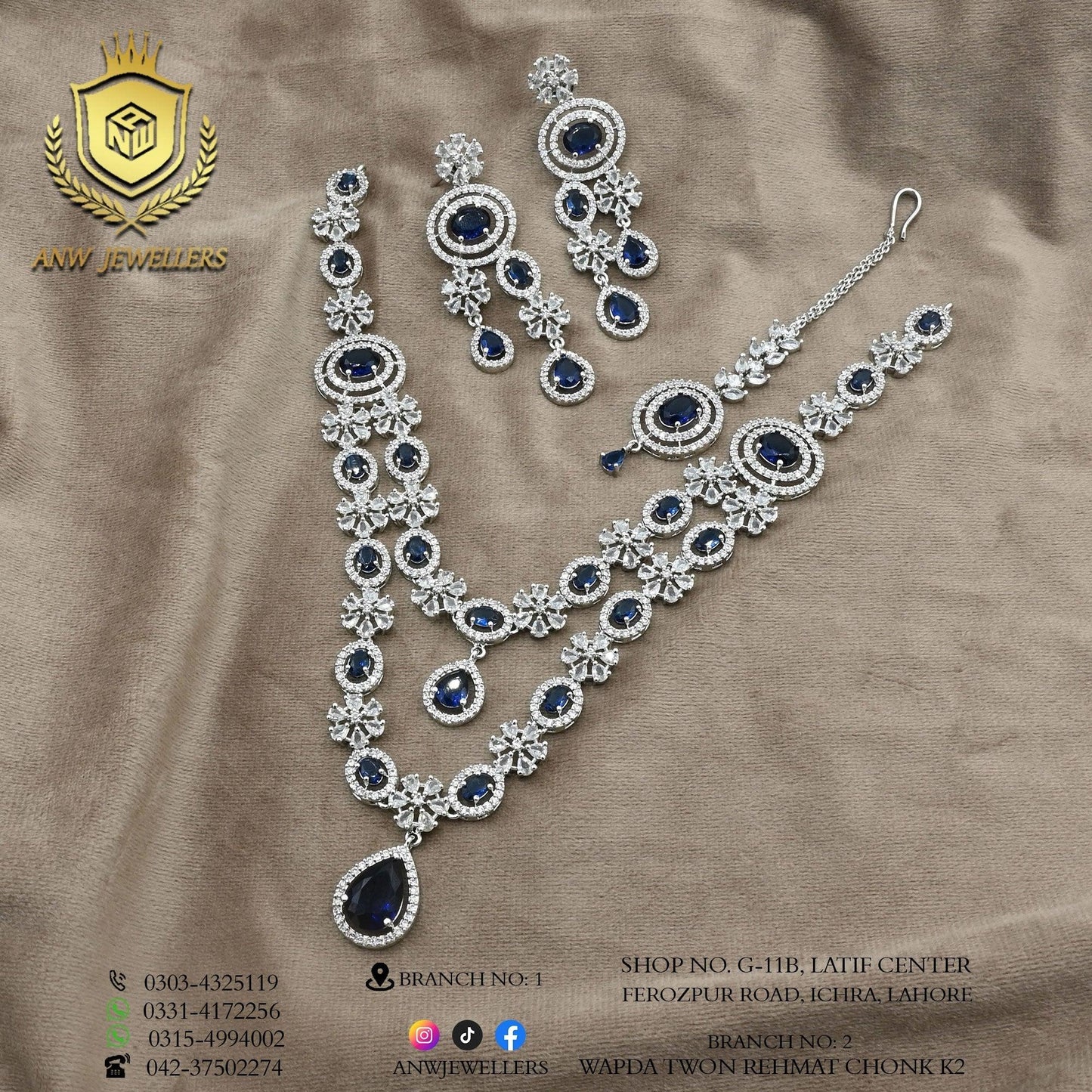 Blue and silver bridal jewelry set with necklace, earrings, maang tikka on beige fabric, ANW Jewellers