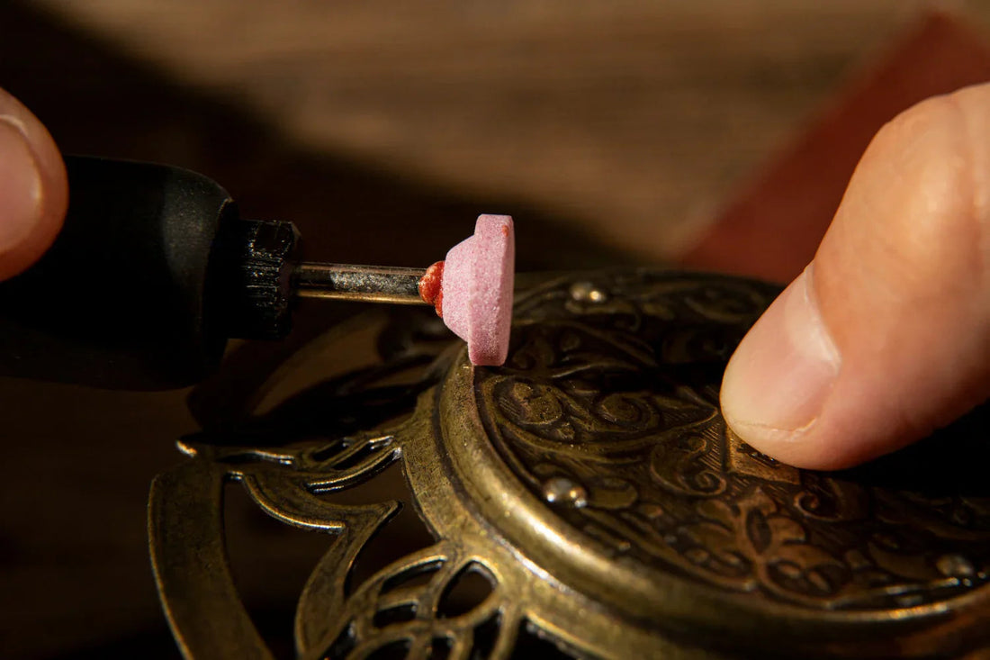 Hand polishing ornate 22K gold jewelry with rotary tool for fine craftsmanship